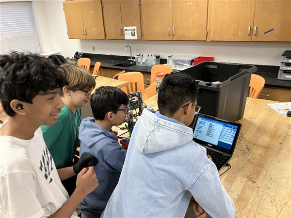 Students coding on a computer.